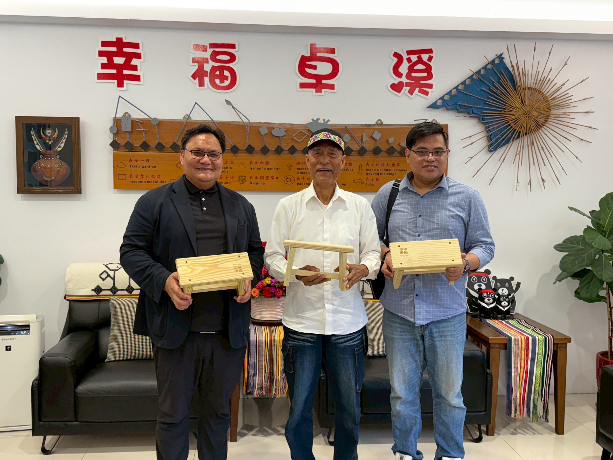 中原原專班師生於卓溪鄉公所進行文化交流,致贈以回收廢木製作之文創椅,展現環保理念與文化尊重。