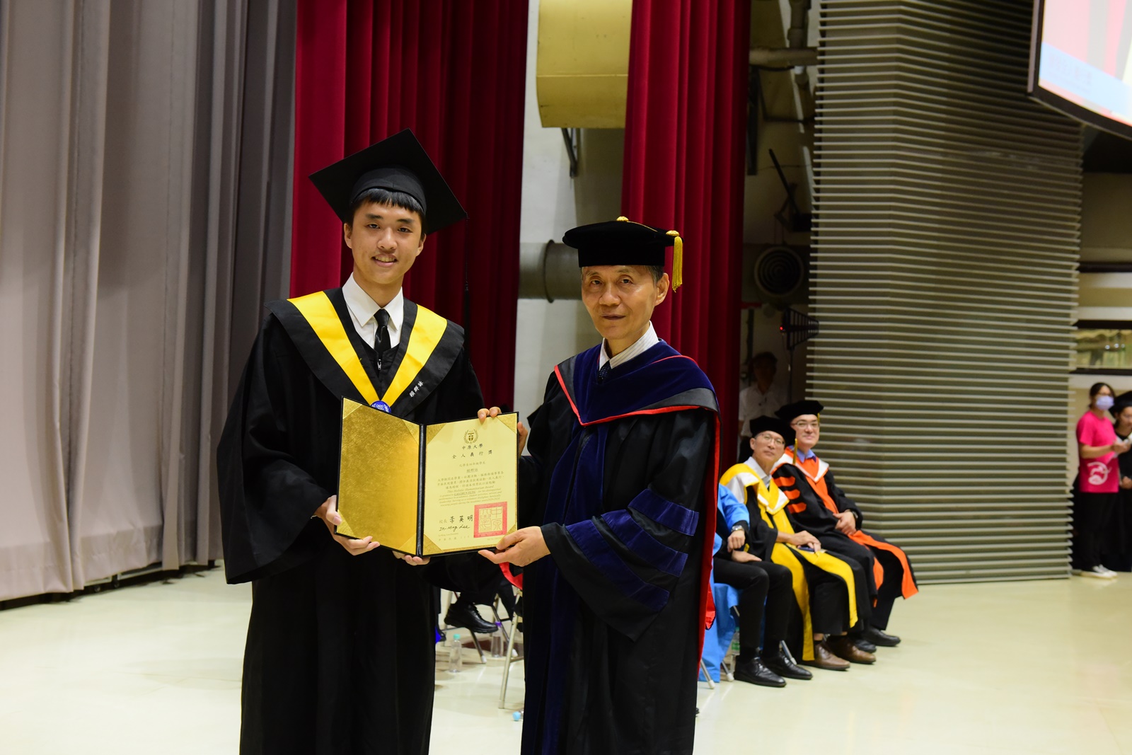 中原大學畢業典禮首度頒發「全人義行獎」，表彰畢業生賴群詠左救人義行。右為中原大學校長李英明。