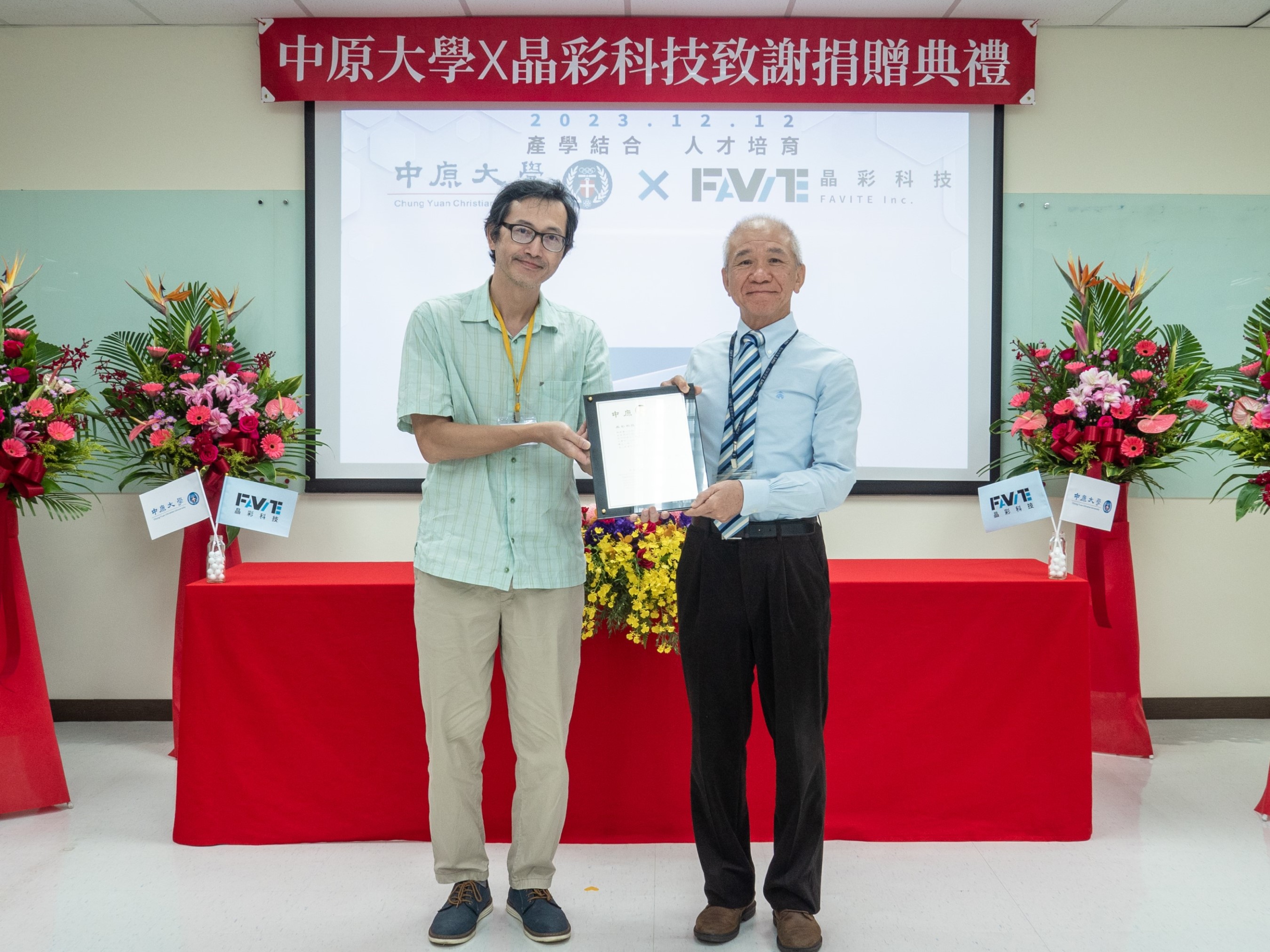 中原大學物理學系主任溫文鈺(左)代表致贈感謝牌予晶彩科技董事長陳永華(右)。