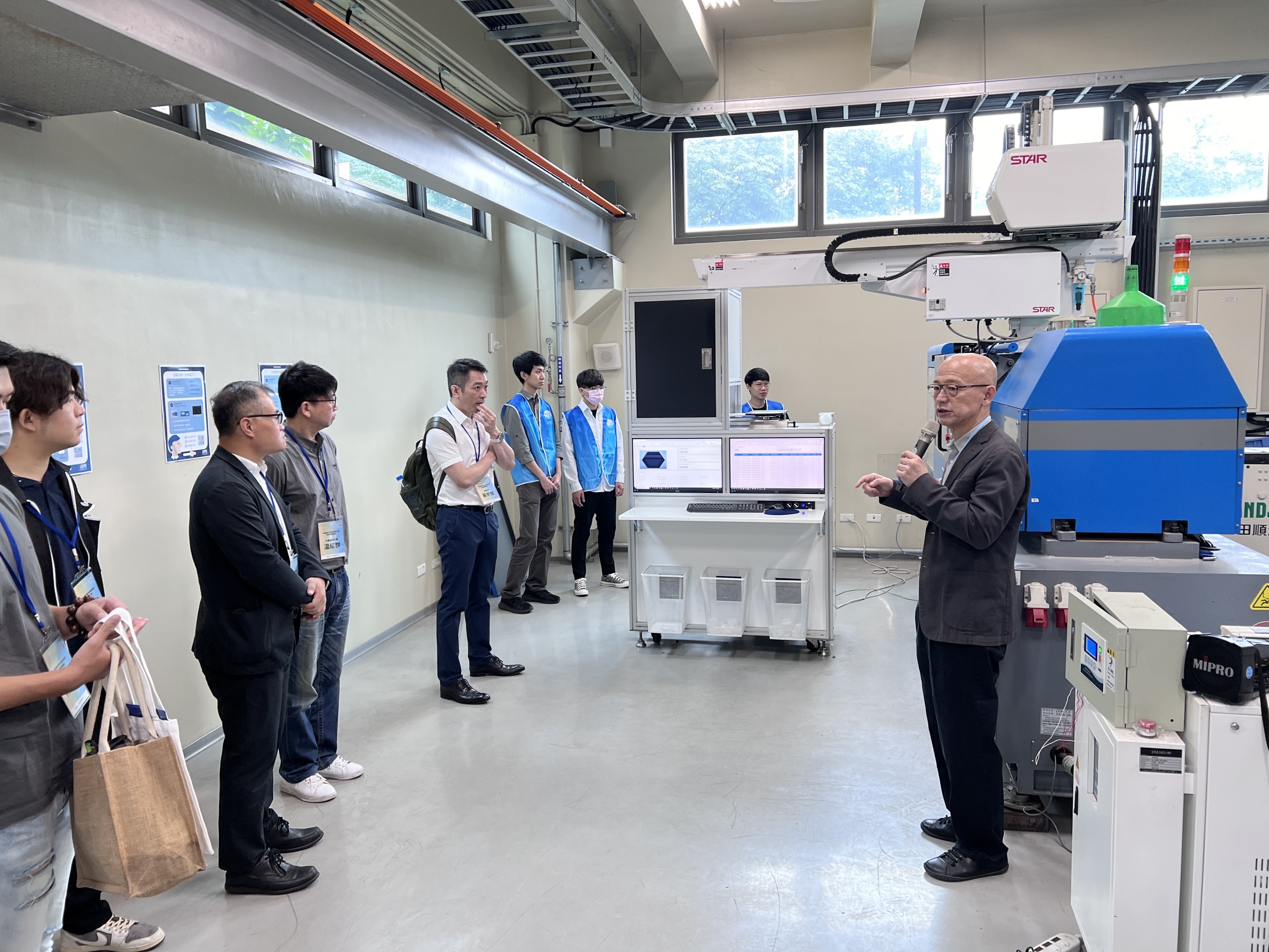中原大學智慧製造研發中心副主任鍾文仁(圖右)展示知行領航館示範產線研發成果。