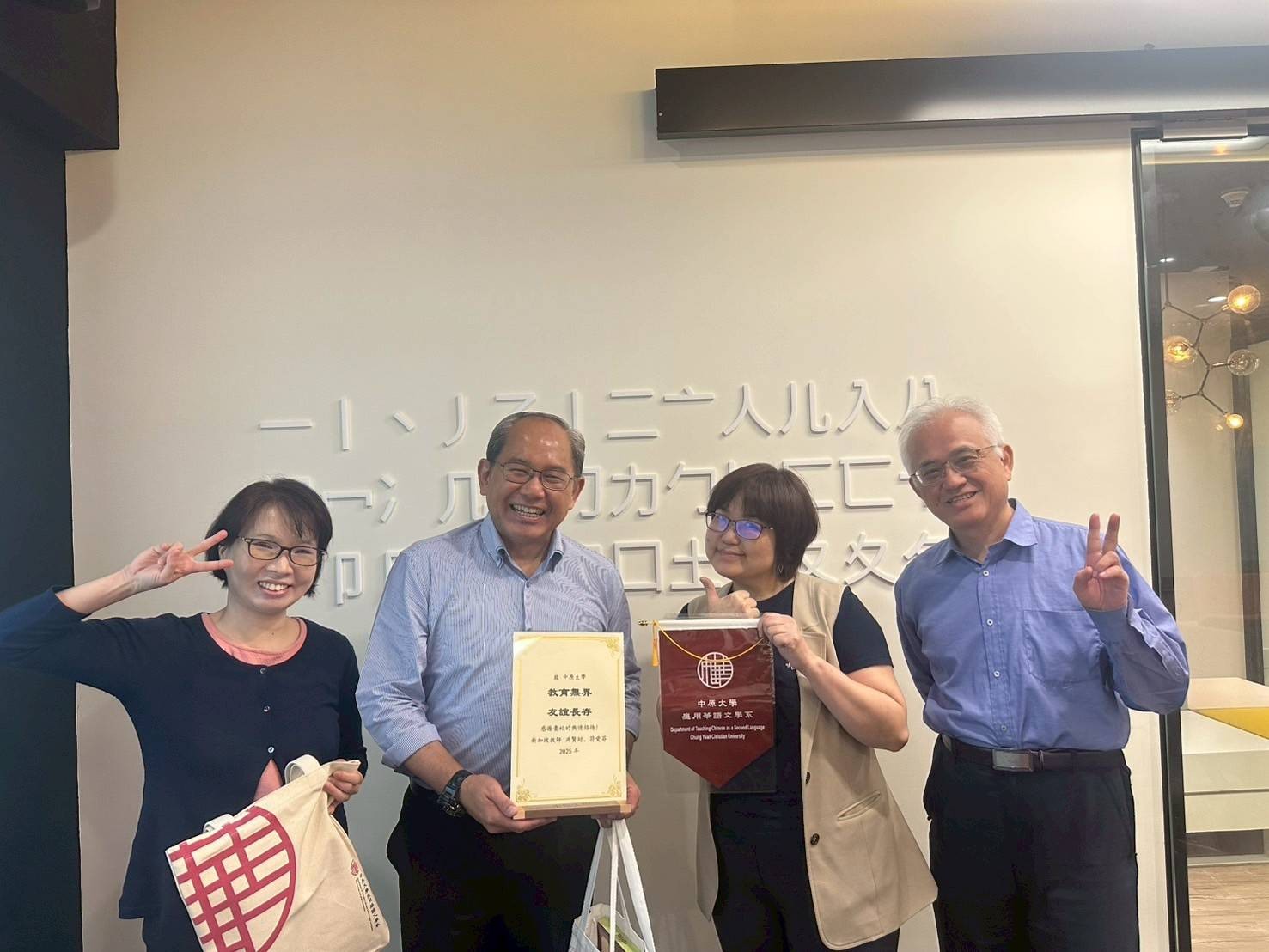中原大學應華系接待新加坡教育工作者，互贈禮品和錦旗。(左起符愛芬老師、洪賢財老師、柳玉芬主任、廖宜瑤老師)
