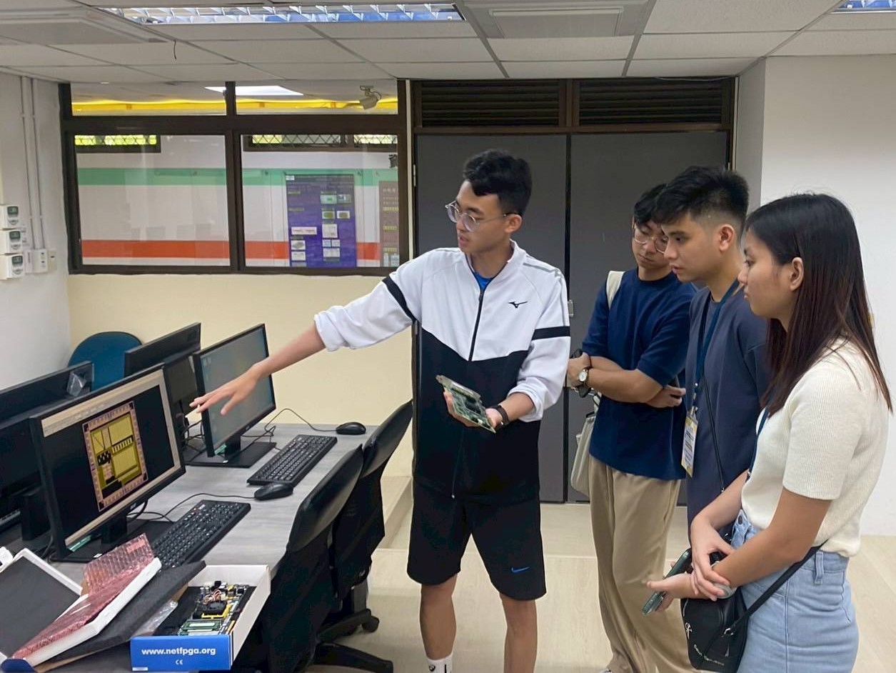 中原大學電機系研究生向菲律賓學生介紹「積體電路設計共構實驗室」中的AI運算設備與應用。