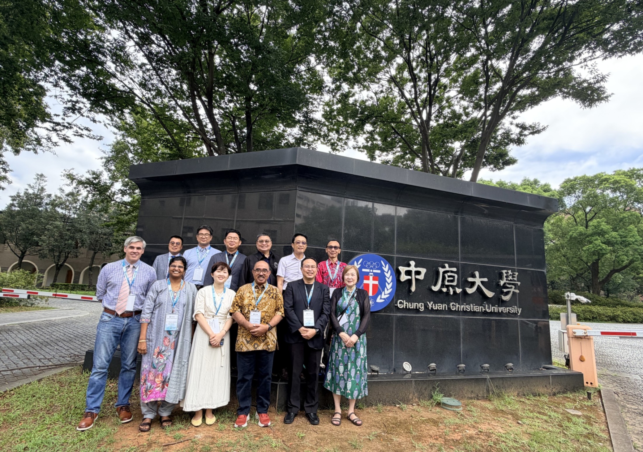 各國會員大學代表於中原大學校門口校名牆前合影留念。