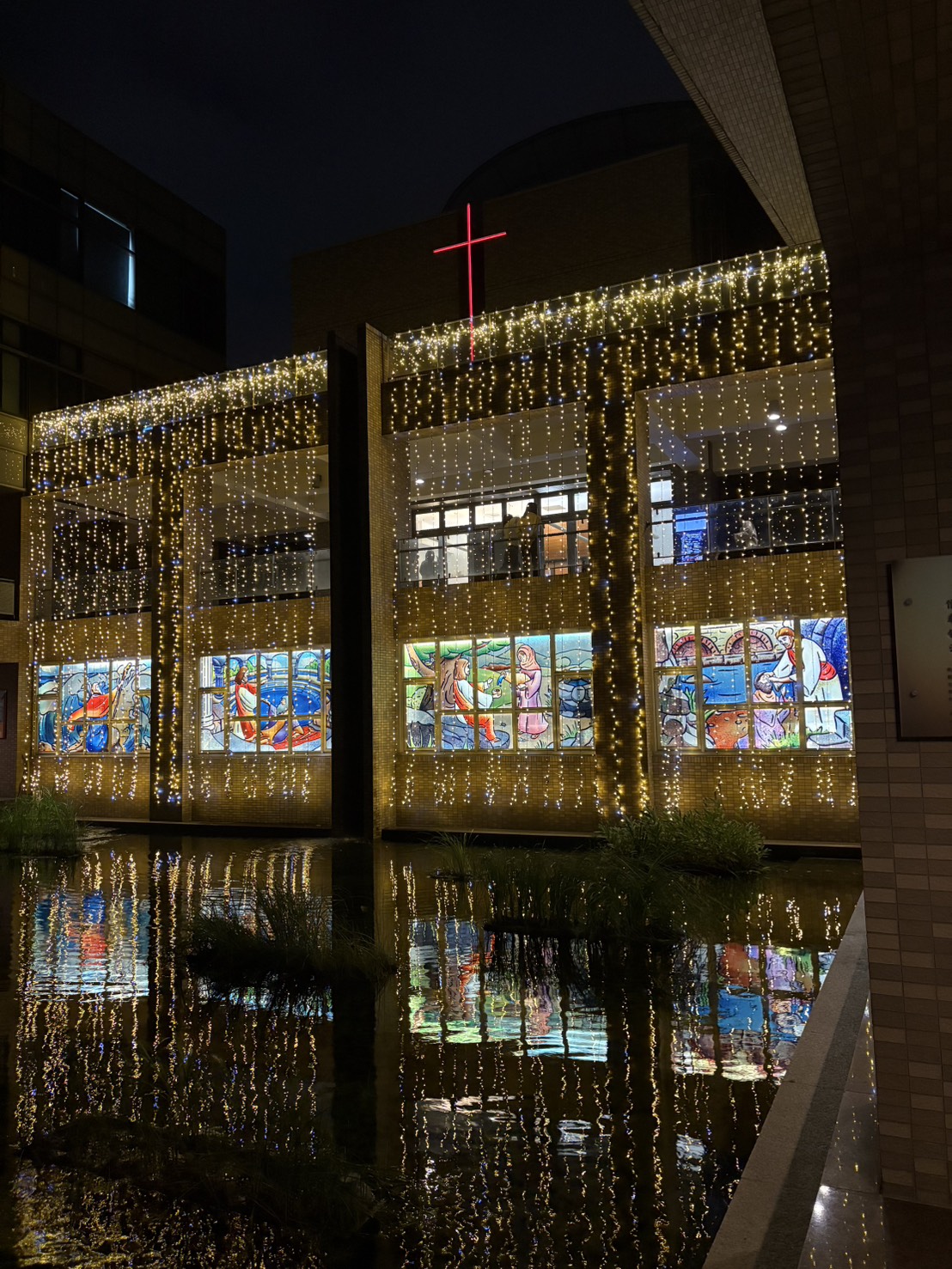 瀑布窗簾燈自樓層垂落，如流動祝福為校園增添柔亮冬日詩意。