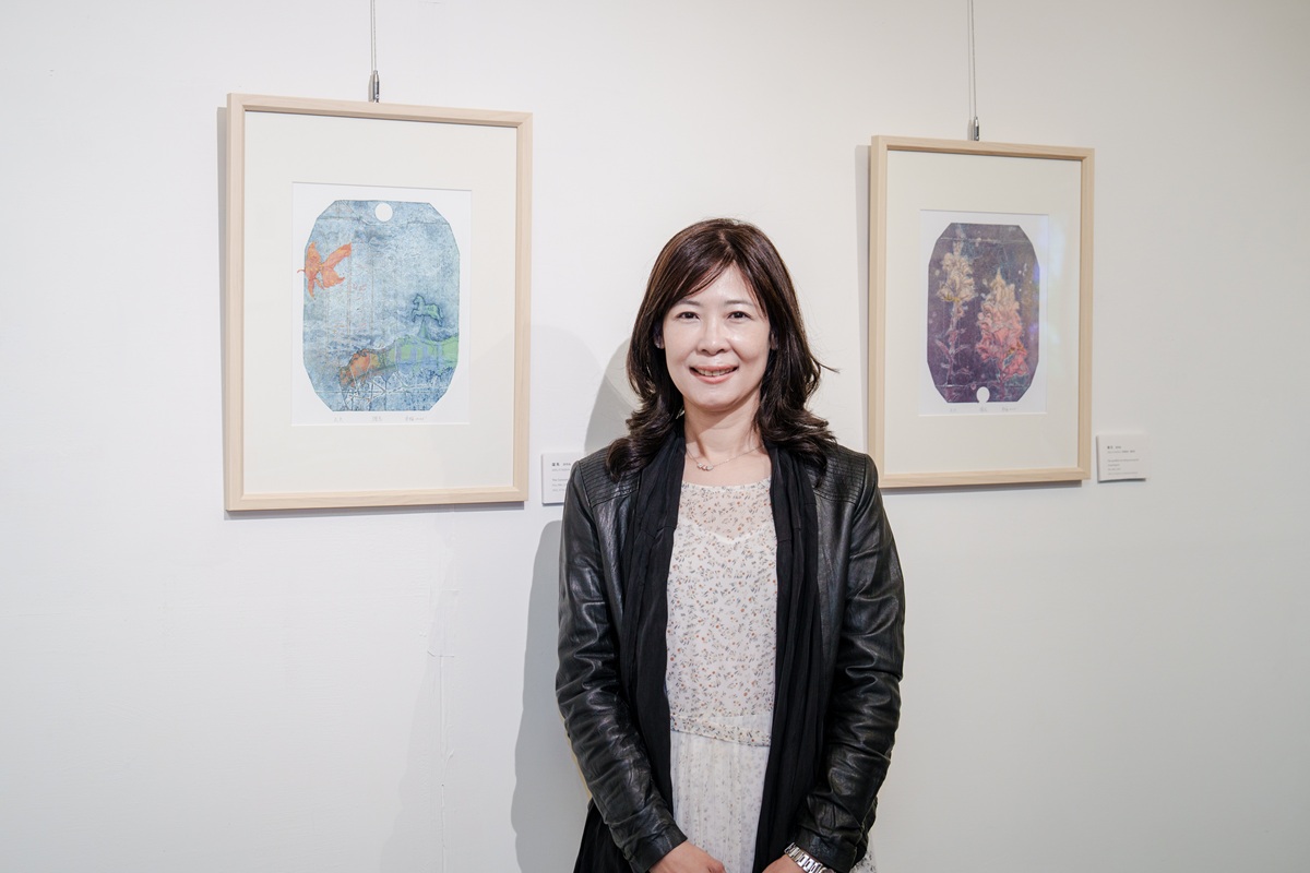 藝術家廖秀梅與她的版畫作品合影。