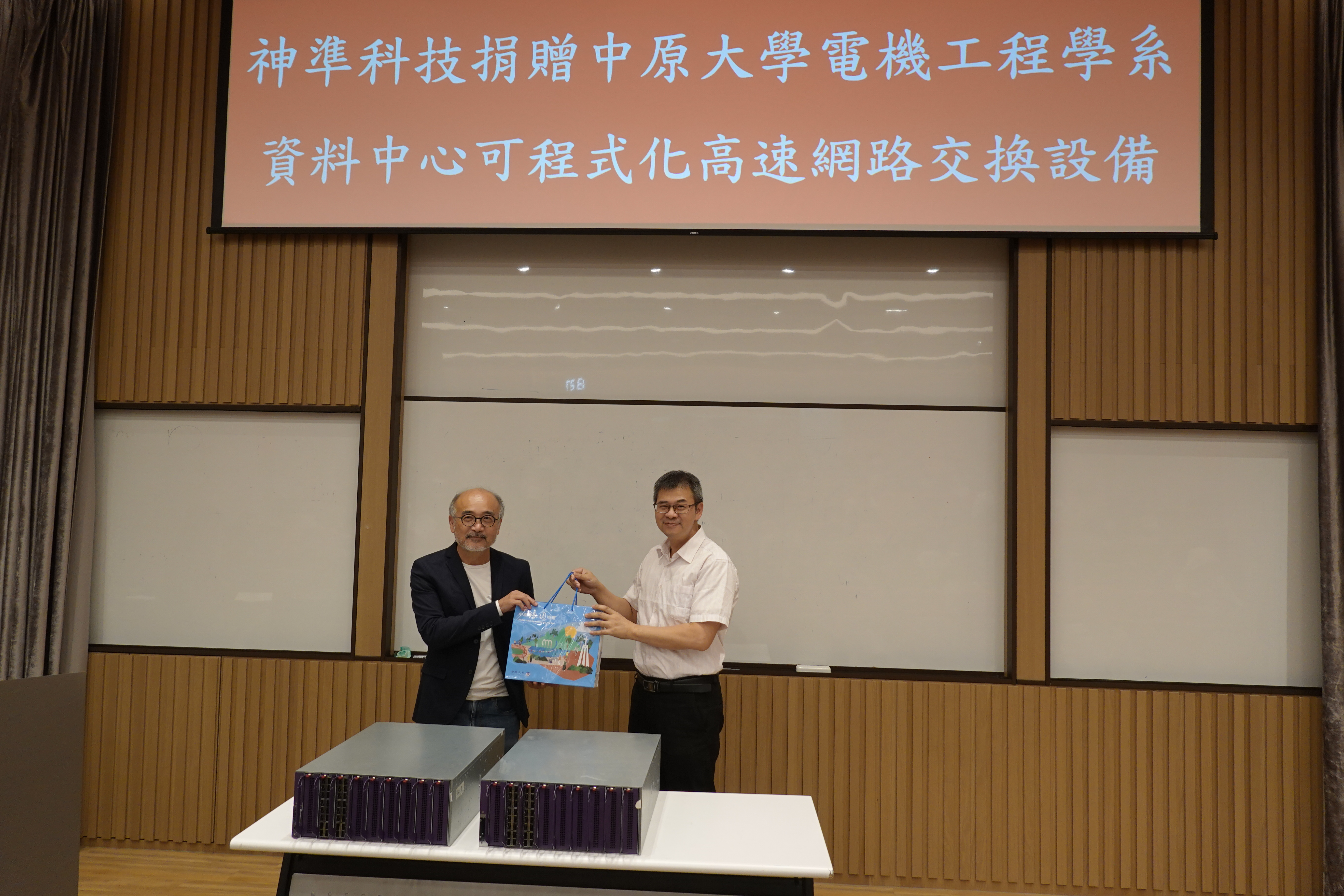 電機系邱謙松主任(右)代表致贈紀念品予林伯彰總經理(左)。